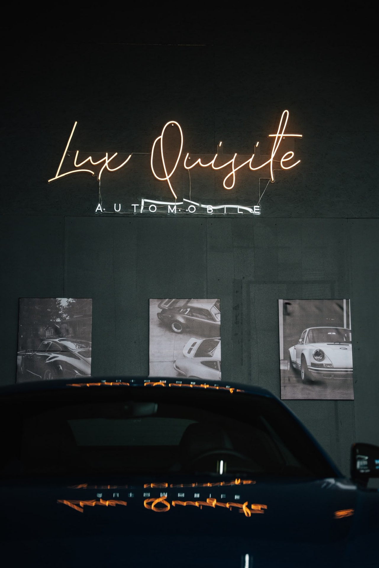 Leuchtendes LUX QUISITE Logo über einem Fahrzeug